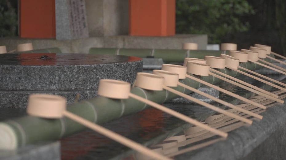 At the temizusha, visitors use a ladle to scoop water from the basin to purify their hands and mouth.