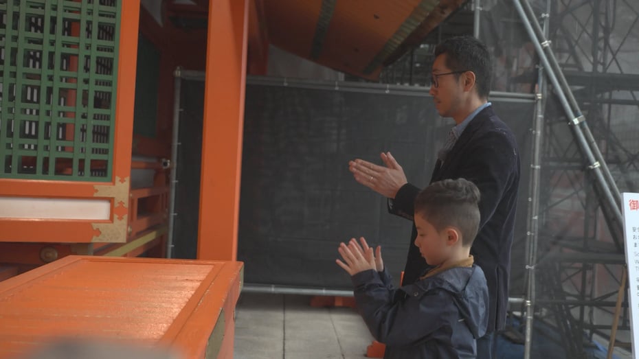 Kenta Goto praying alongside his son. The basic etiquette at a shrine is bow–clap–bow.