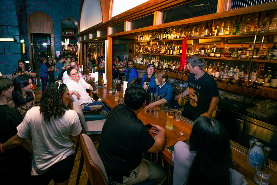 Bartenders from Allegory, Service Bar, and Origin Bar serving drinks from behind the counter.