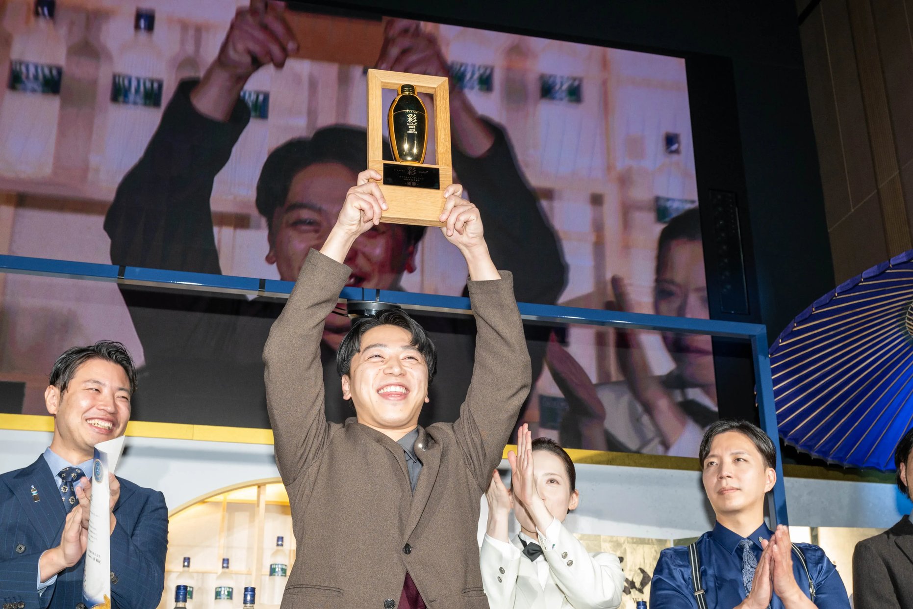 優勝トロフィーを両手で高く掲げる初代日本チャンピオンの髙橋裕也（たかはし・ゆうや）さん