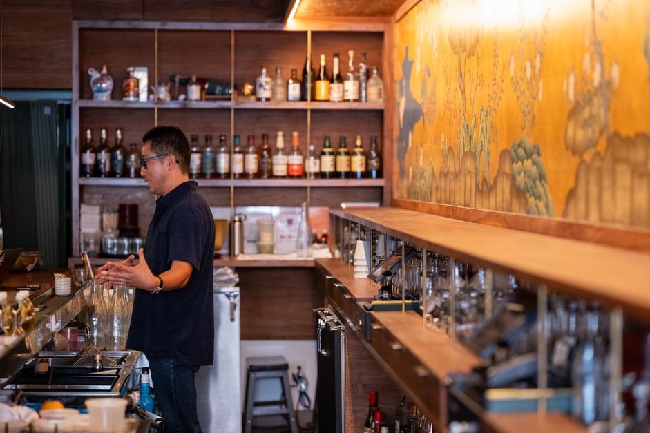 Kenta Goto standing behind the bar.