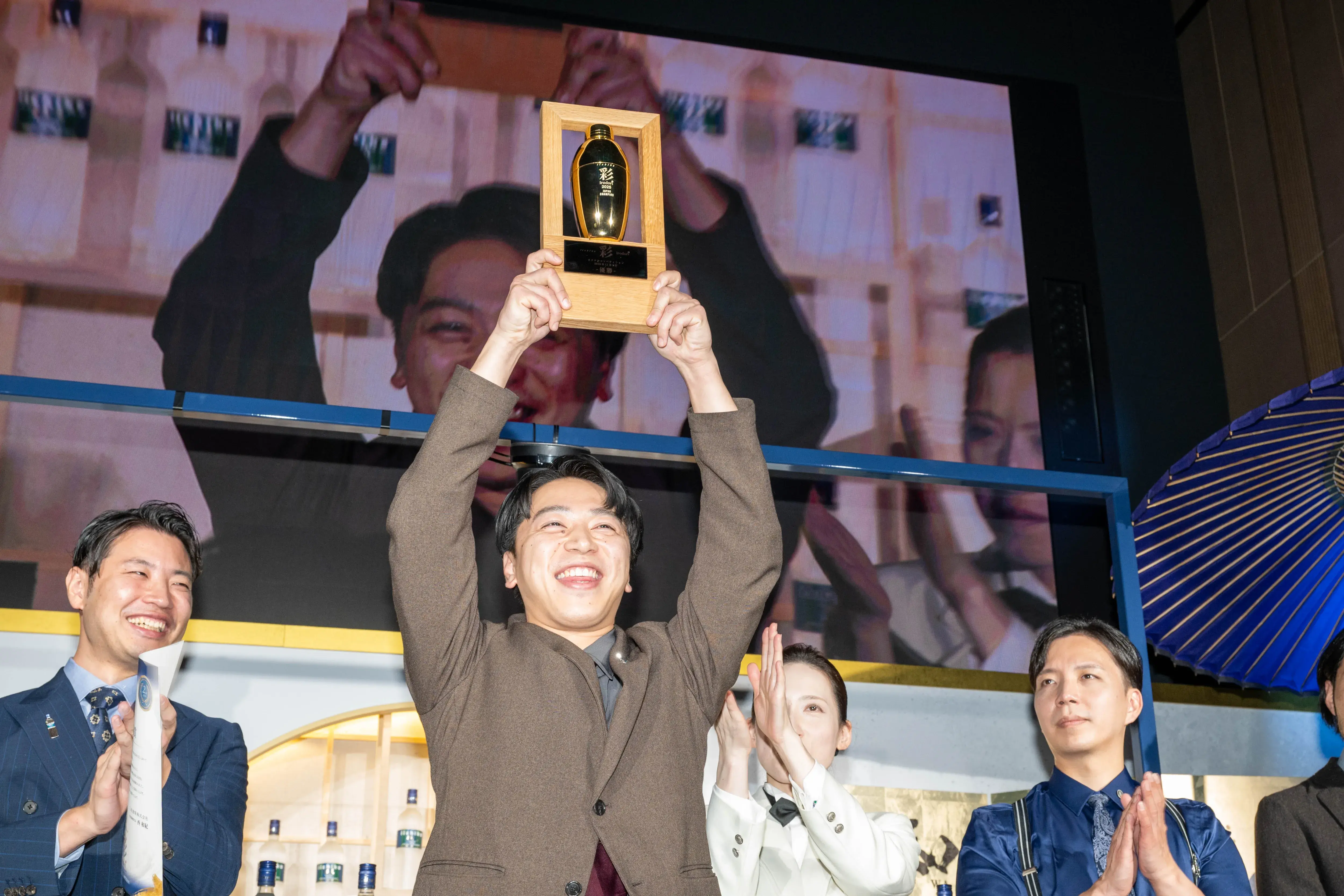 優勝トロフィーを両手で高く掲げる初代日本チャンピオンの髙橋裕也（たかはし・ゆうや）さん